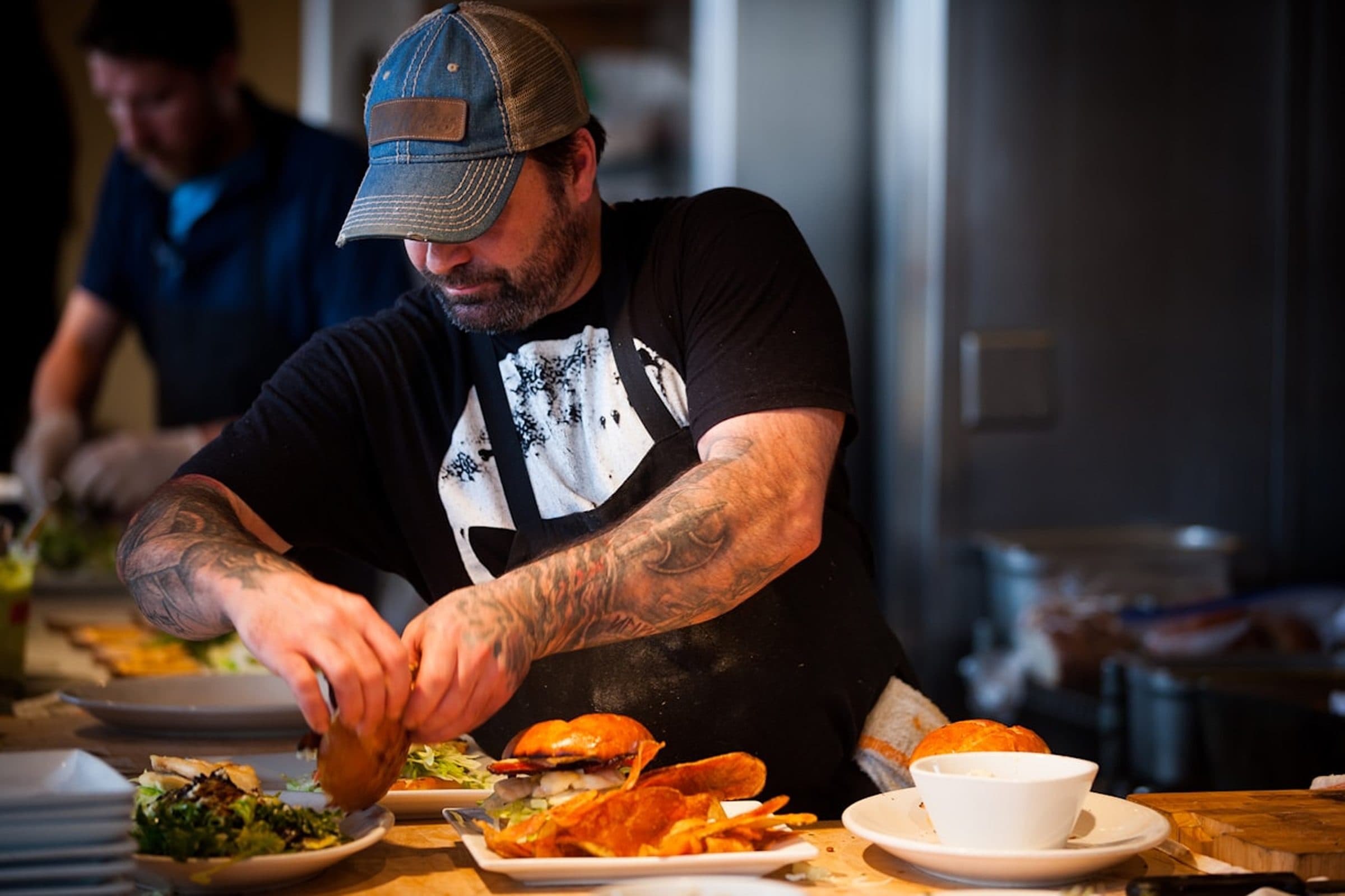 A chef plating dishes on a busy kitchen line